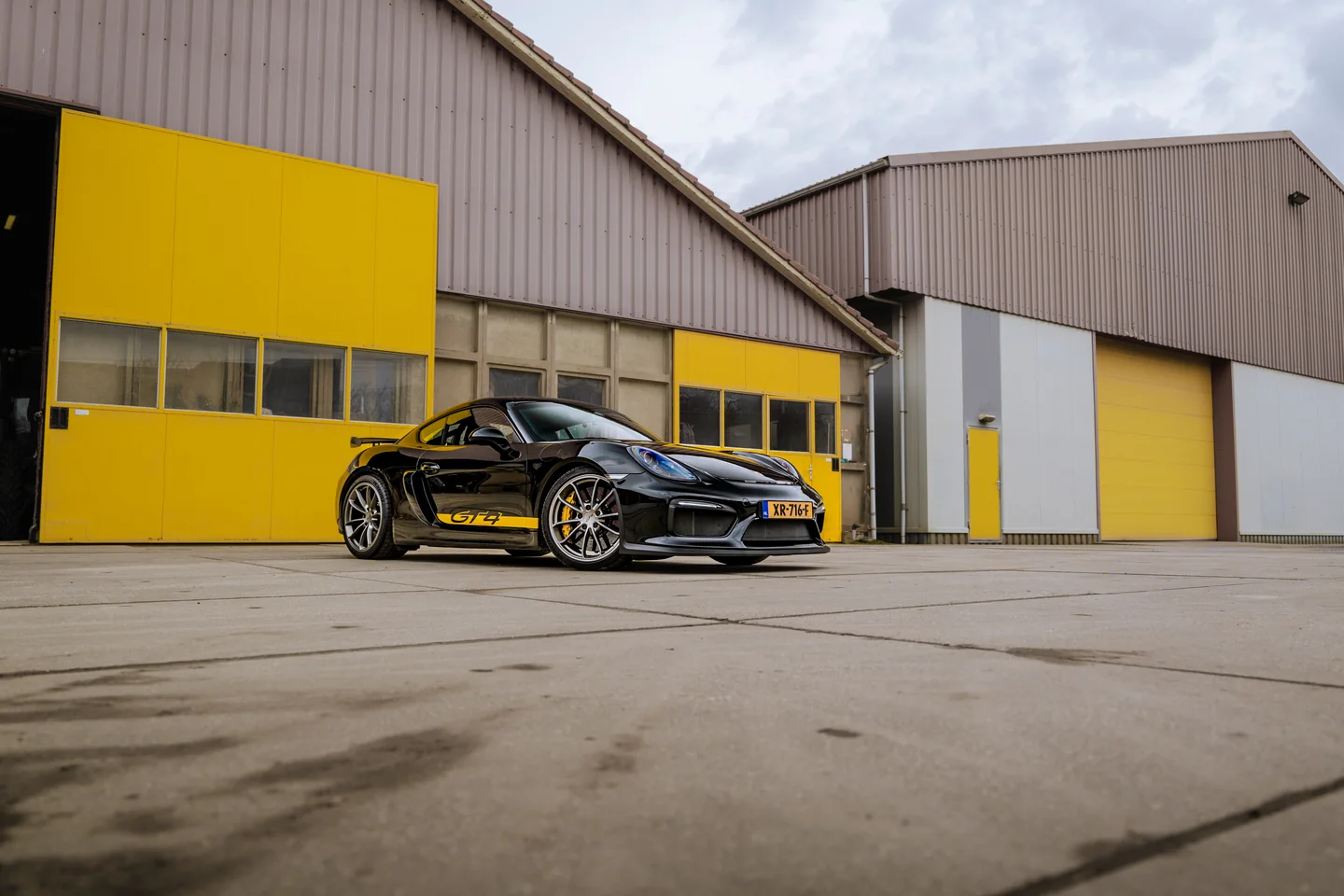 Sportwagen voor een gele bedrijfshal