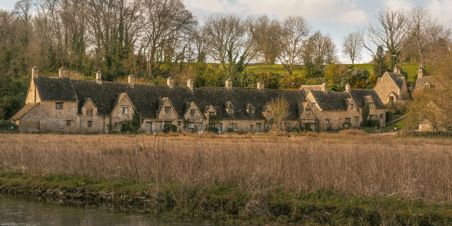 Historische stenen woningen aan de rand van een veld