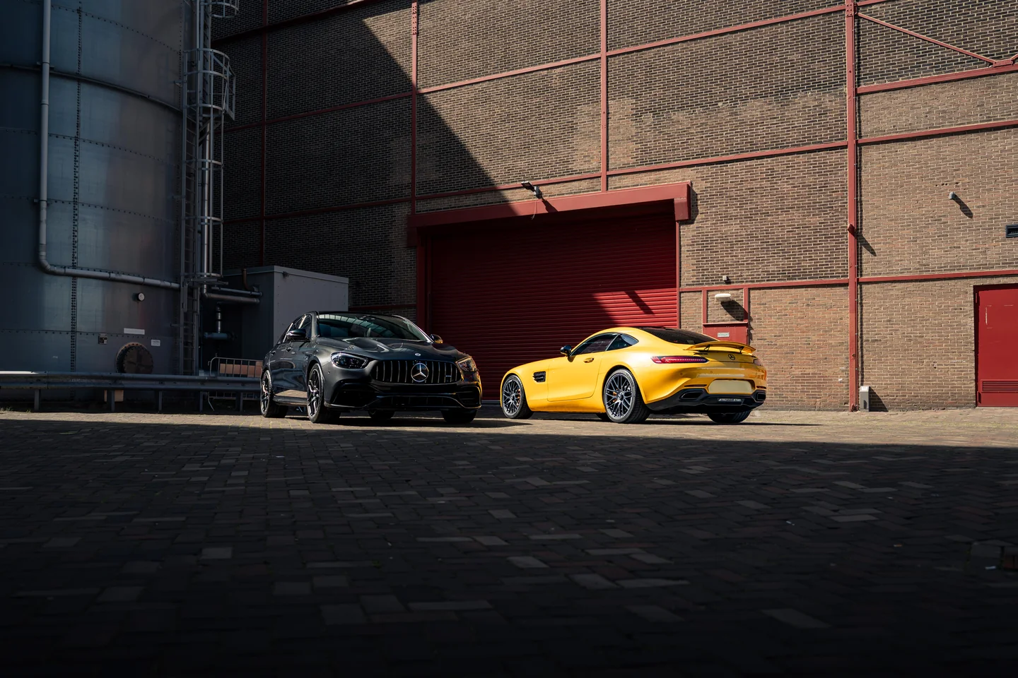 Twee sportwagens op een industriële locatie