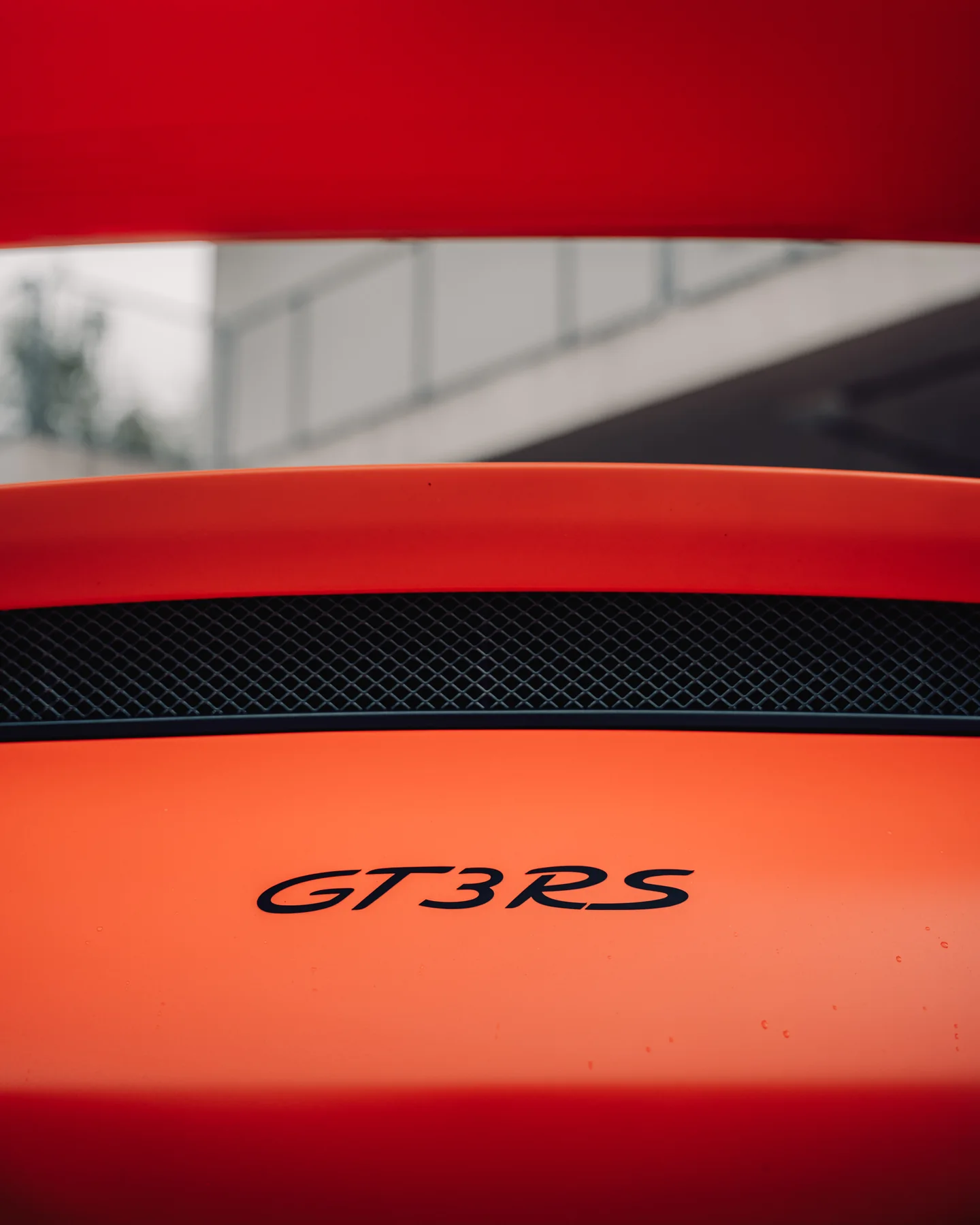 Detail van het GT3 RS-logo op een oranje carrosserie