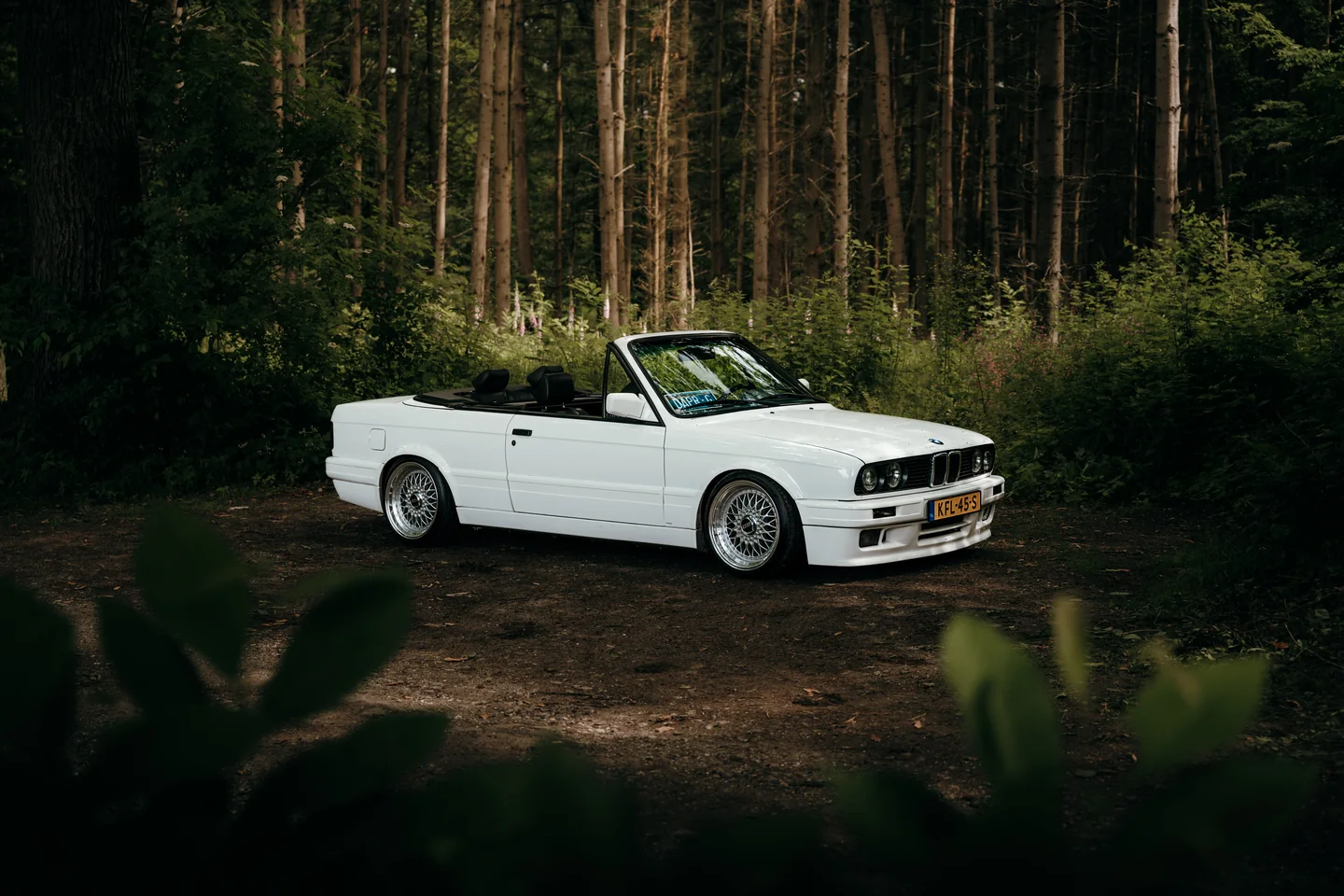 Witte klassieke cabriolet in een bos