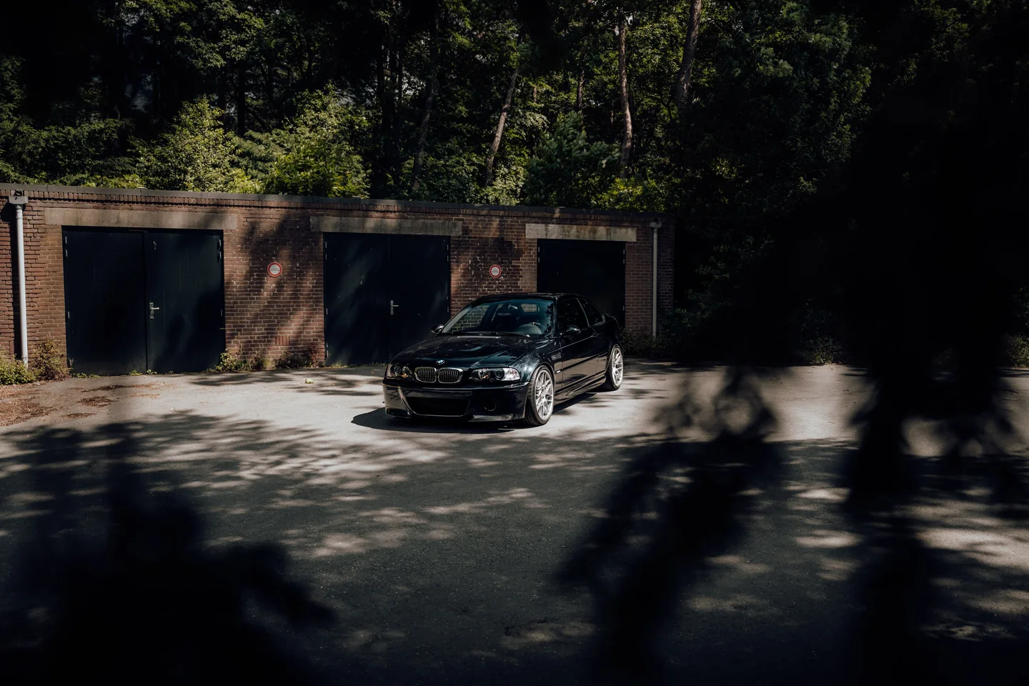 Donkere BMW voor garages in hard zonlicht