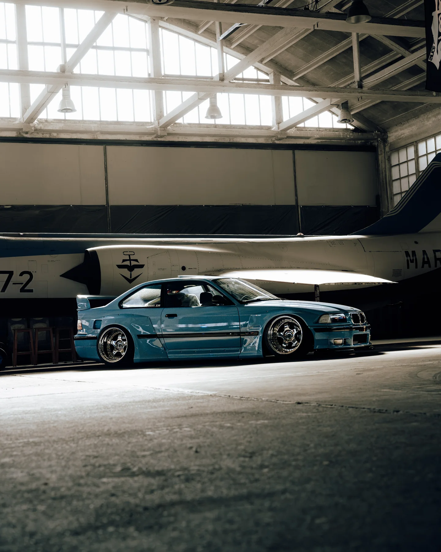 Blauwe BMW voor een historisch vliegtuig